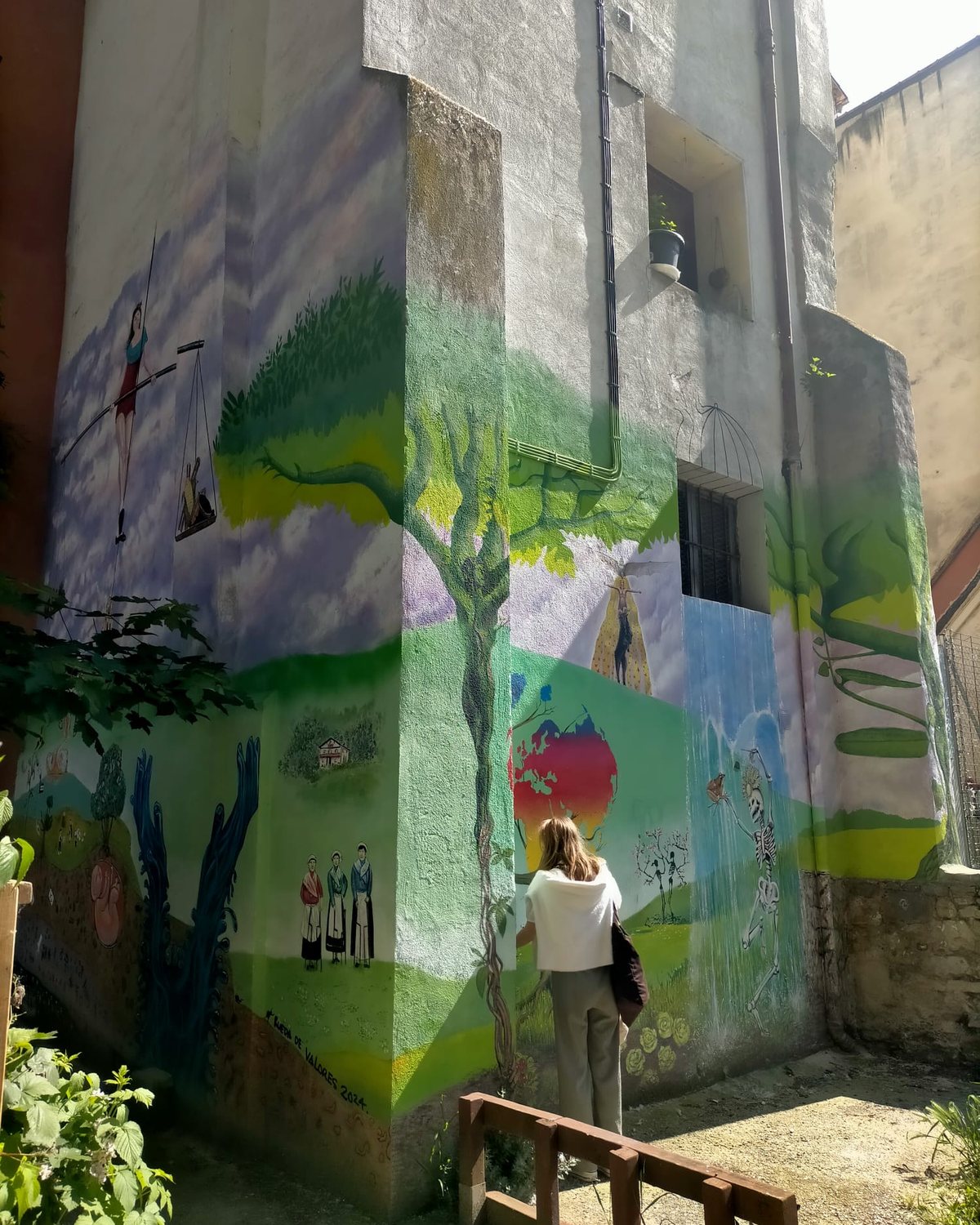 A large colourful mural painted on the corner of a building in Pamplona